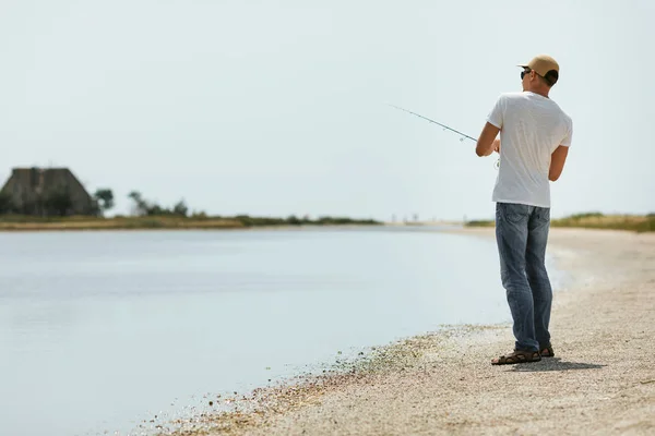 Young man fishing at sea — Stock Photo, Image