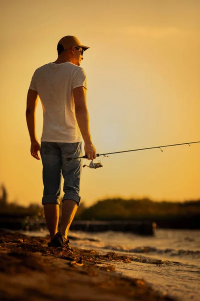 Young man fishing at sea — Stock Photo, Image