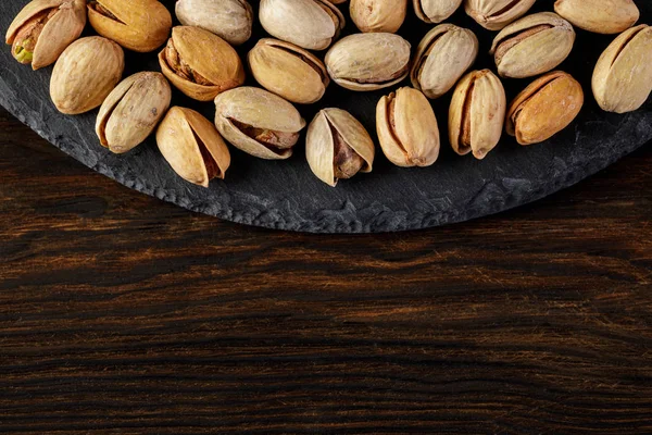 Salted pistachio nuts on stone board — Stock Photo, Image