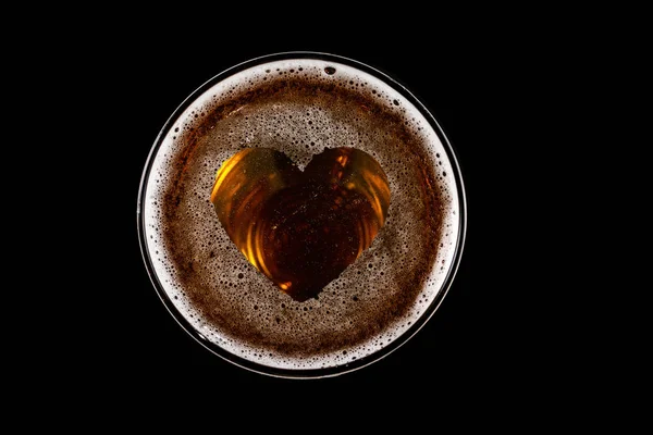 Форма сердца на пене в бокале пива — стоковое фото