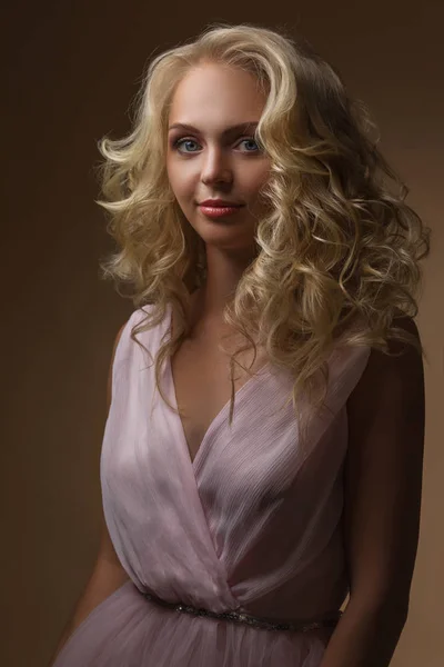 curly blonde woman in gorgeous pink dress