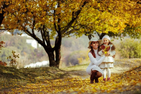 Charmante schöne Mutter küsst ihre kleine Tochter Mädchen — Stockfoto