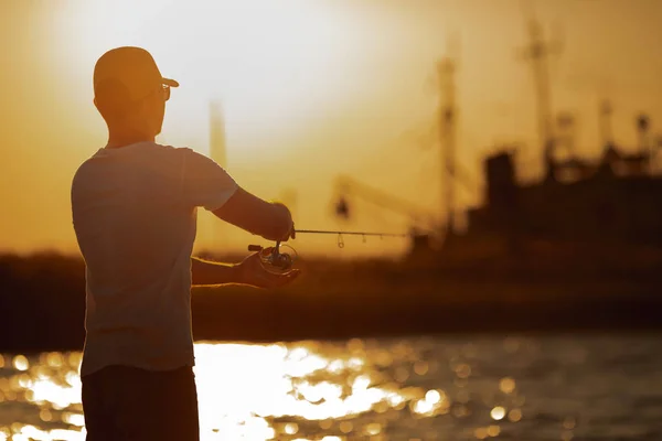 Молодой человек рыбачит в море — стоковое фото