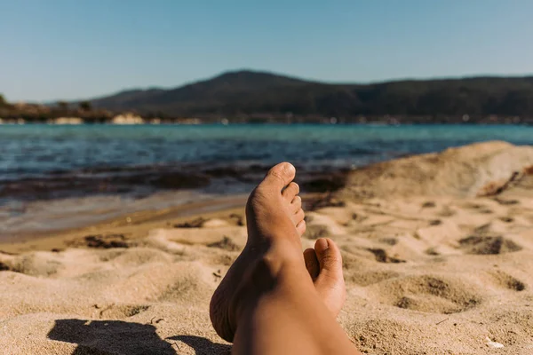 Piernas de una joven acostada en la playa — Foto de Stock