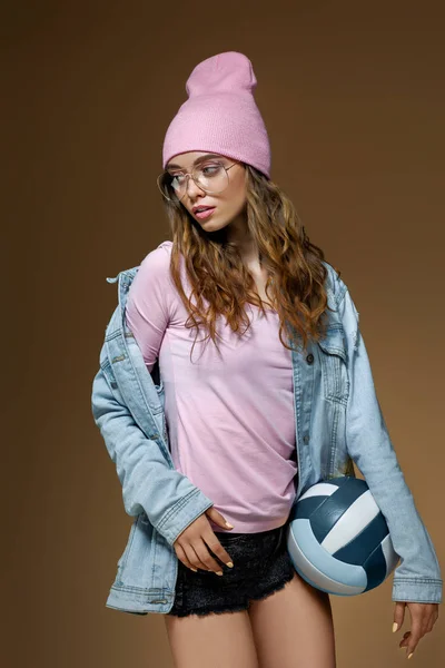 Chica en jeans, un sombrero rosa y gafas con estilo con una pelota —  Fotos de Stock