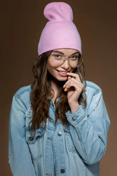穿牛仔裤夹克的女孩,粉红色的帽子和时尚的眼镜 — 图库照片