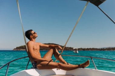 denizde yatta dinlenen adam.