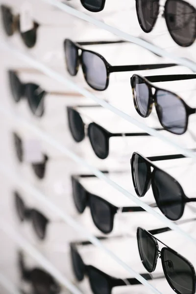 Fashionable sunglasses on a shelf in store