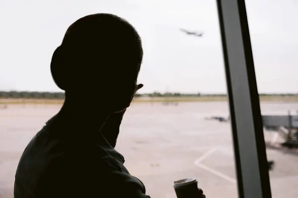 Silhouette einer Frau, die auf ein Flugzeug wartet. — Stockfoto