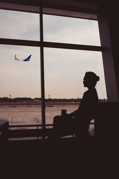 Silhouette einer Frau, die auf ein Flugzeug wartet. — Stockfoto