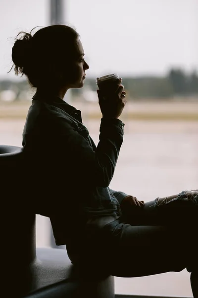 Silueta de mujer esperando avión de vuelo . — Foto de Stock