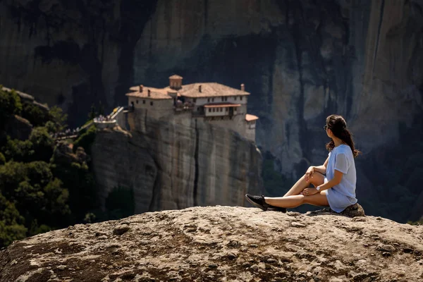 Mujer turística sentada en la cima de la montaña en un hermoso acantilado — Foto de Stock