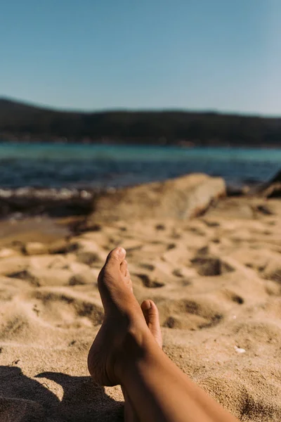 浜辺に横たわる若い女性の足 — ストック写真