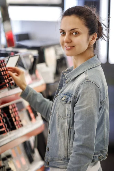 Cliente feminino testando batom na loja de maquiagem — Fotografia de Stock