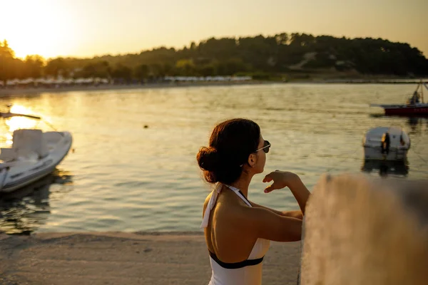 Mujer en traje de baño y gafas de sol mirando el barco — Foto de Stock