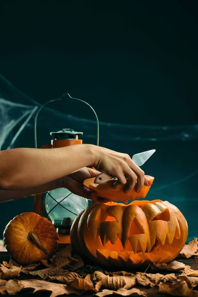Woman prepares for halloween and carving a pumpkin — Stock Photo, Image