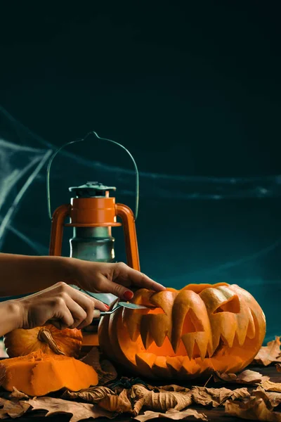 Woman prepares for halloween and carving a pumpkin — Stock Photo, Image