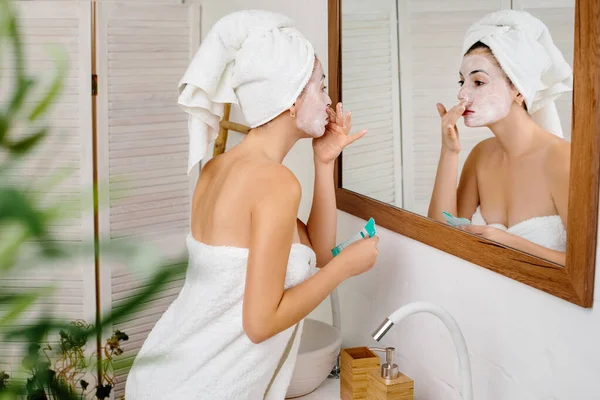 Woman is applying mask on her face — Stock Photo, Image