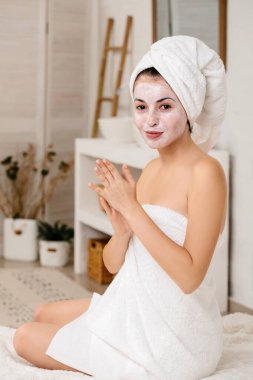 Kadın yüzüne maske takıyor.