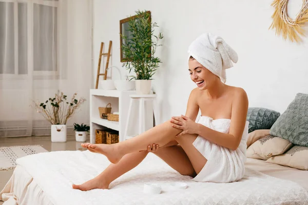 Mujer aplicando crema en sus piernas — Foto de Stock