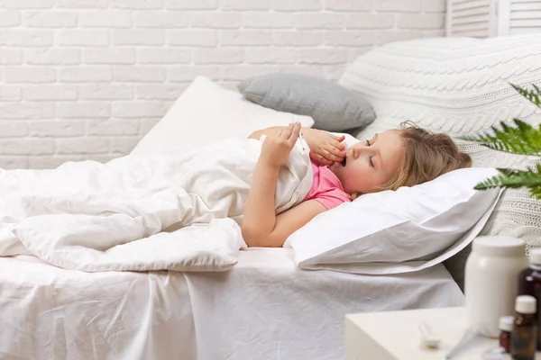 Ziek meisje in bed liggen met thermometer — Stockfoto