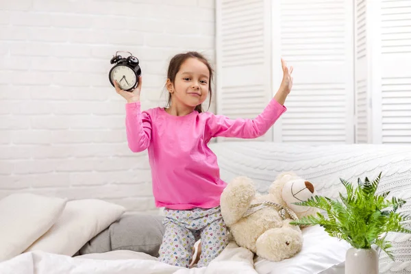 Menina em pijama com relógio — Fotografia de Stock