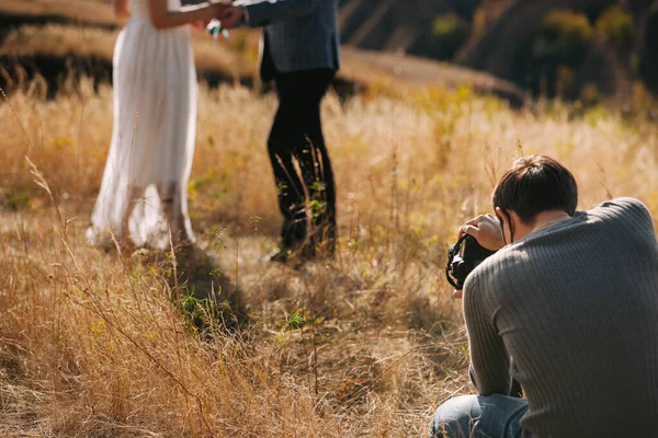 Bröllopsfotograf tar bilder på bruden och brudgummen — Stockfoto