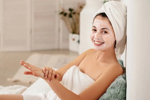 Woman is applying mask on her face — Stock Photo, Image