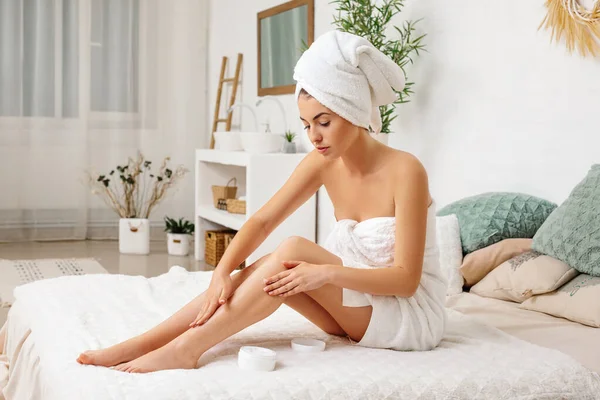 Mujer aplicando crema en sus piernas — Foto de Stock