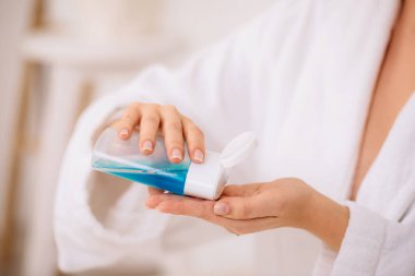 Kadınların elleri makyajı silmek için tonik tutar.