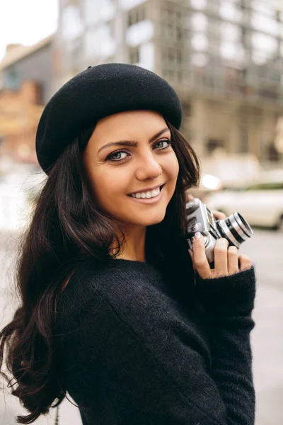 Woman holding retro camera and taking picture — Stock Photo, Image