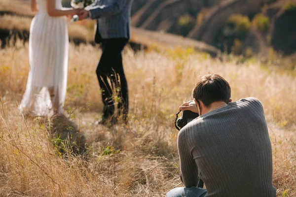 Bröllopsfotograf tar bilder på bruden och brudgummen — Stockfoto