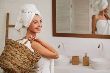 woman holding wicker basket with laundry
