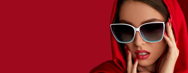 Дівчина в білих сонцезахисних окулярах і червоному кожусі — стокове фото