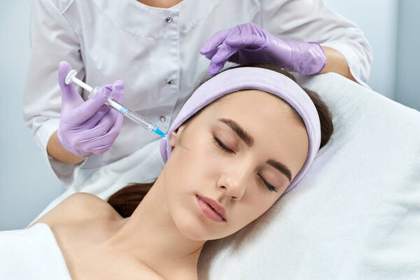 young woman getting beauty injections in salon