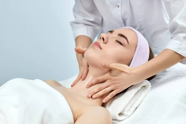 Jovem bela mulher recebendo a massagem facial — Fotografia de Stock