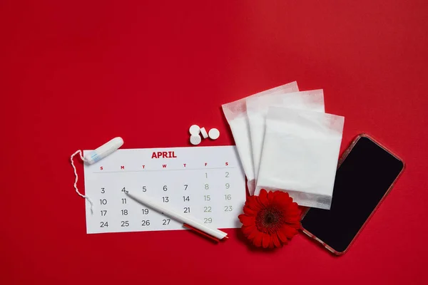 Менструальные подушки и красный цветок — стоковое фото