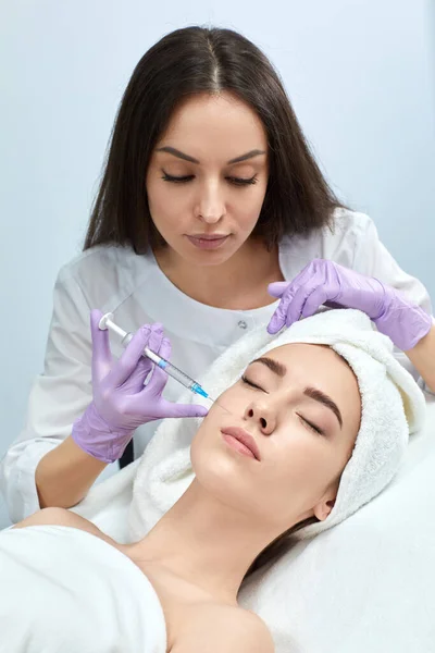 Mujer joven recibiendo inyecciones de belleza en el salón — Foto de Stock