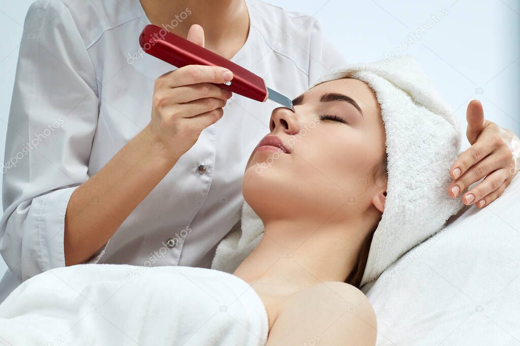 womans face while procedure ultrasound cleansing