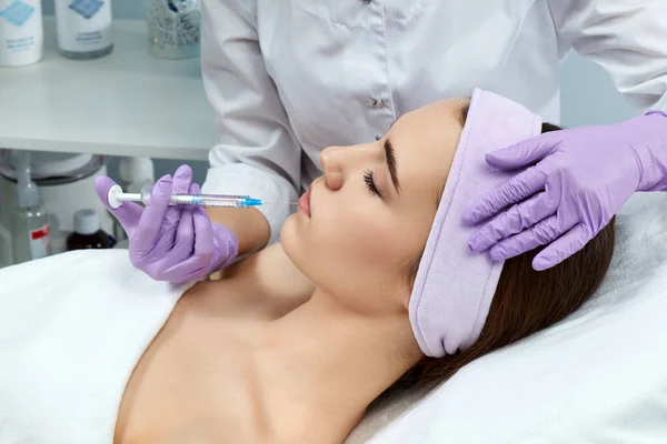 Mujer joven recibiendo inyecciones de belleza en el salón — Foto de Stock