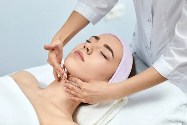 Young beautiful woman receiving the facial massage — Stock Photo, Image
