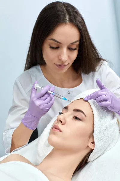 Mujer joven recibiendo inyecciones de belleza en el salón —  Fotos de Stock