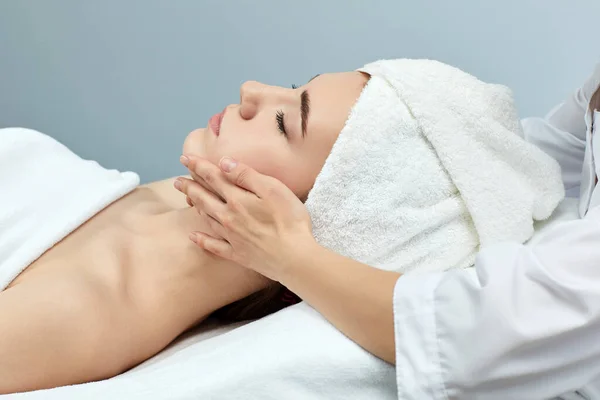Young beautiful woman receiving the facial massage — Stock Photo, Image