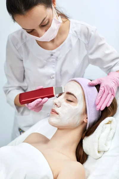 womans face while procedure ultrasound cleansing