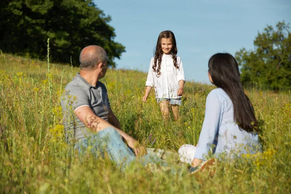 Famille heureuse dans une prairie dans une journée ensoleillée — Photo