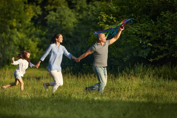 Çocuklu mutlu bir aile uçurtma fırlatıyor. — Stok fotoğraf