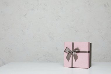 Pembe hediye kutusu beyaz masada.
