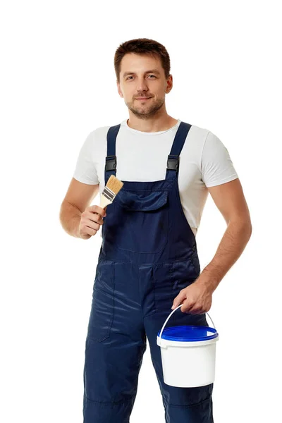 Repairman in blue uniform holding paint brush and can with paint — Stock Photo, Image