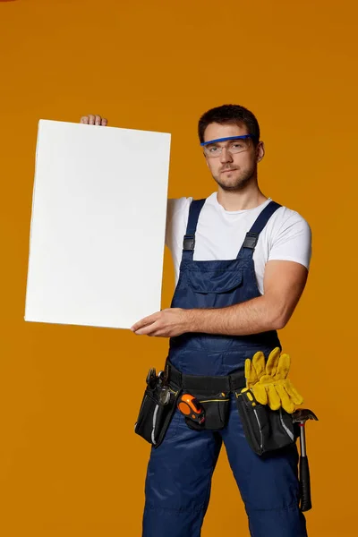 Repairman worker holding empty blank board. — Stock Photo, Image