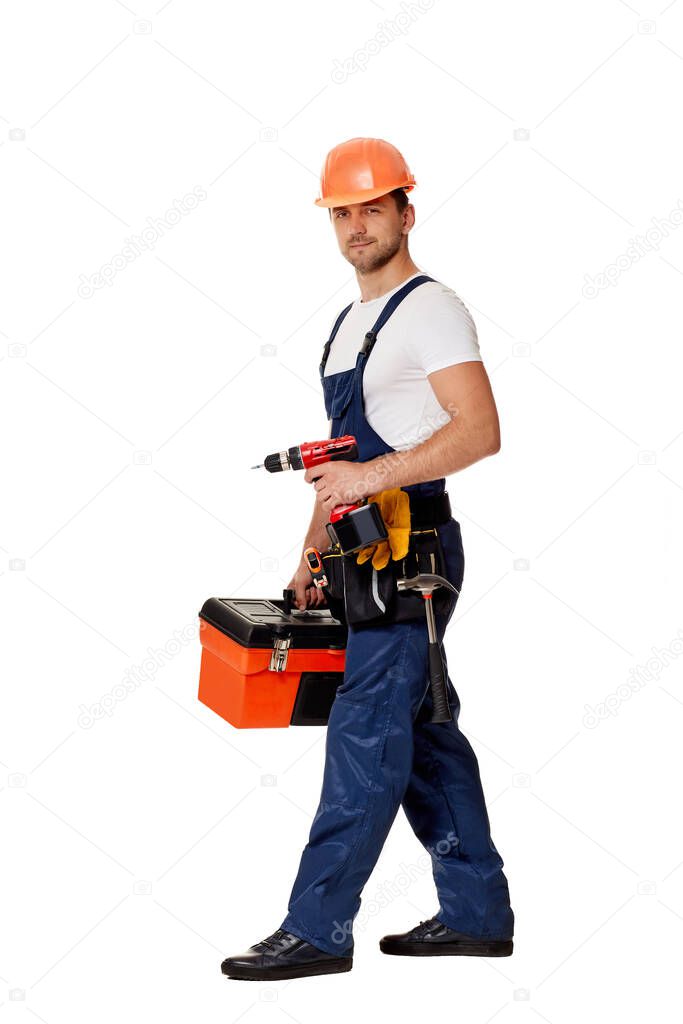 caucasian repairman worker in uniform and helmet holding cordless screwdriver.